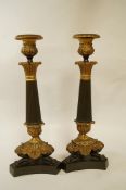 A pair of early 19th century bronze and ormalu candlesticks on waisted triform base,