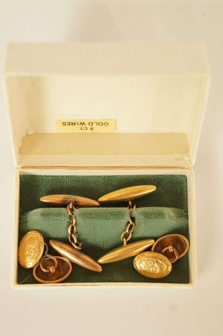 A pair of cufflinks, stamped '18ct' and maker 'WJH', of plain torpedo panels with chain connectors,