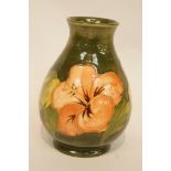 A Moorcroft pottery vase, decorated with the Hibiscus pattern, green background,