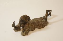 An Austrian bronze Arab figure of a boy lying with pen in hand, impressed marks, no.