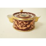 An early 19th century Coalport porcelain inkstand of circular form with loop handle scrolls on a