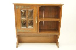 An Arts and Crafts style wall cabinet with four panel convex glazed door, 75cm high, 76.
