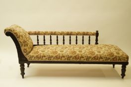 An Edwardian mahogany chaise longue lacking casters with turned legs,