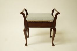 An early 20th century mahogany two handled piano stool on cabriole legs,