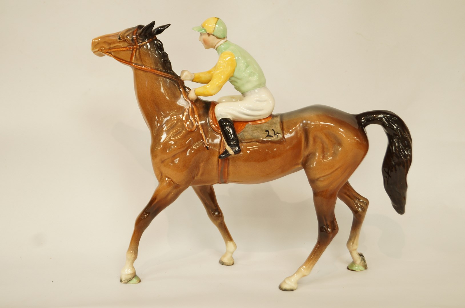 A Beswick horse and jockey, wearing yellow and green silk, printed marks in black,