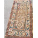 An early 20th century hand woven rug with four hexagonal lozenges within four borders,