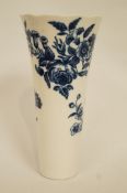 An English porcelain trumpet shaped vase, transfer printed in underglaze blue with flower sprays,