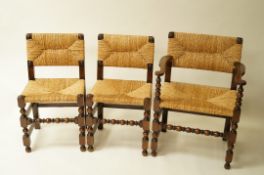 A set of six stained beech chairs with rush seats and backs, above turned legs and stretchers,