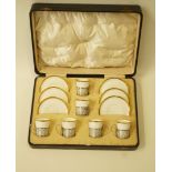 A set of six Shelly coffee cups and saucers in original case, the cups in silver mounts,