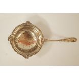 A silver tea strainer, by Mappin & Webb, decorated in the rococo style, 14.