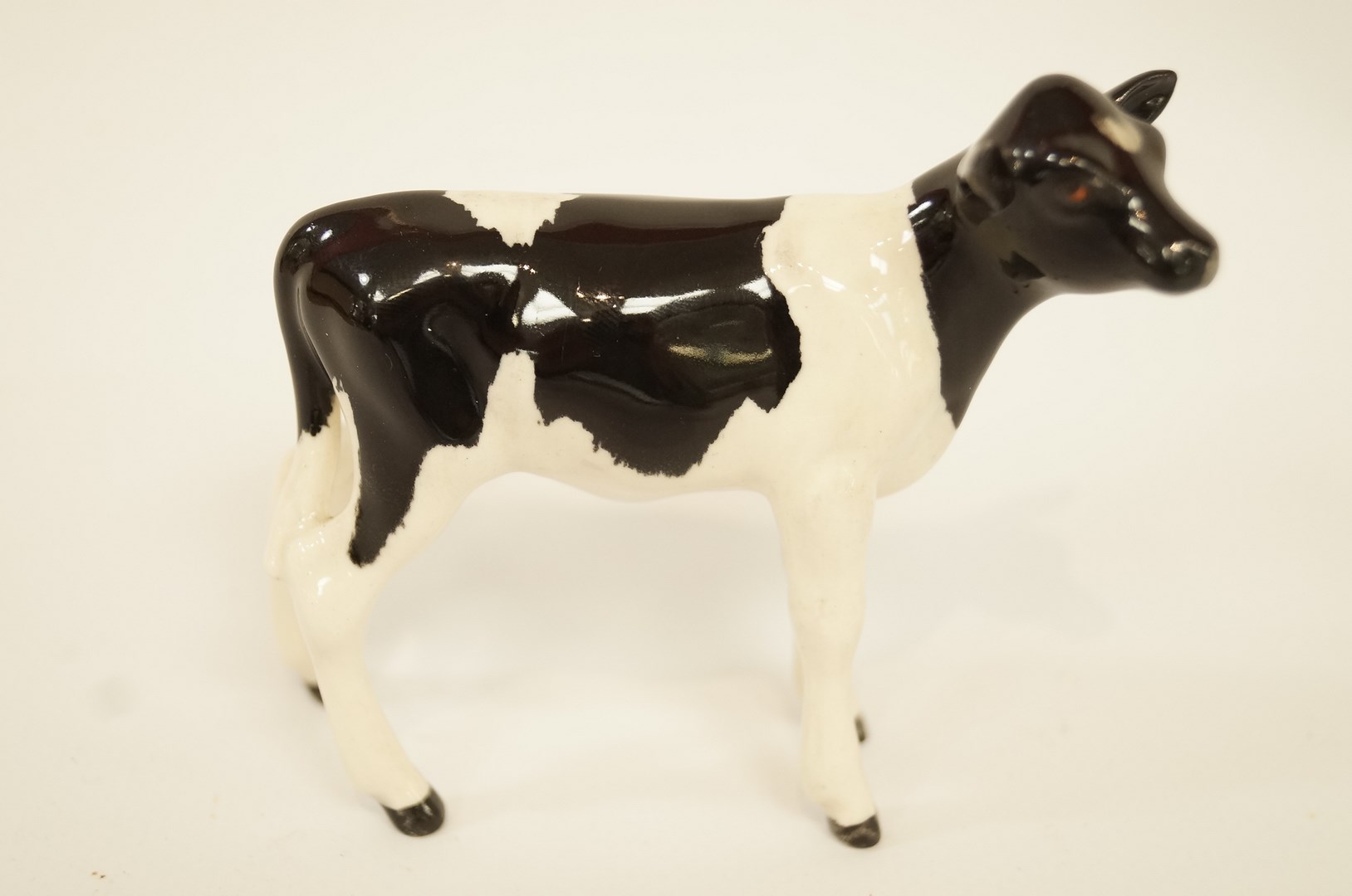 A Beswick figure of a Friesian calf, printed marks in black, 7.