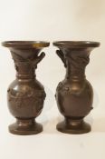A pair of Japanese bronze vases, moulded with dragons chasing flying birds, 15.