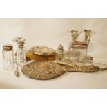 A set of three glass jars with silver covers, a small mirror, a hat pin stand,