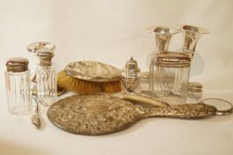 A set of three glass jars with silver covers, a small mirror, a hat pin stand,