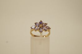 A 9ct gold amethyst dress ring, the eight marquise cuts enclosing a small central diamond,