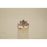 A 9ct gold amethyst dress ring, the eight marquise cuts enclosing a small central diamond,