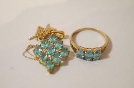 A three stone blue topaz 9ct gold dress ring; with a 9 ct gold blue topaz pendant on a chain; 4.