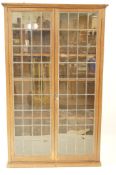 A 20th century oak standing bookcase with two lead glazed doors, 178cm high, 109cm wide,