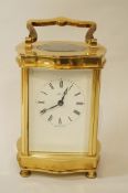 A modern brass carriage clock with a white enamel dial, by Henley,
