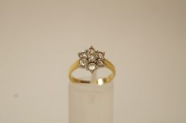 A seven stone diamond platinum cluster ring, the brilliant cuts totalling approximately 0.