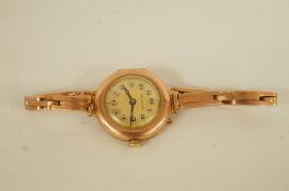 De Luxe, a lady's wrist watch, the gilt dial with black Arabic numerals and hands,