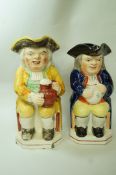 An early 20th century Staffordshire pottery Toby jug and cover, 24cm high and another,