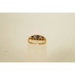 An 18ct gold diamond and sapphire five stone ring, with pieced gallery, Birmingham 1902,