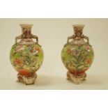A pair of early 20th century Japanese earthenware vases, decorated with lillies and butterflies,