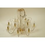 A modern twelve branch glass chandelier, with swags and drop pendants,