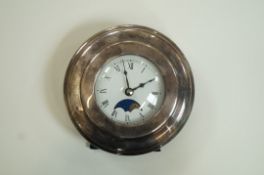 A modern silver mounted clock, with a moon phase and quartz movement, marks worn,