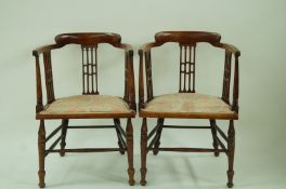 A pair of Edwardian stained beech arm chairs with pierced splats and turned legs linked by