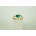 An emerald and diamond three stone ring, stamped '18ct' and 'Plat', the rectangular cut emerald, 5.