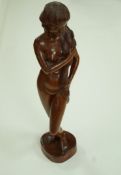 A 20th century Indonesian carved figure, the base carved "Hand made in Bali (Indonesia)",