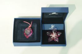 A Swarovski flower head brooch;and a Swarovski crystal pendant on a leather cord;
