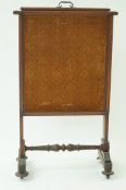 A Victorian mahogany fire screen, with flared feet on casters,