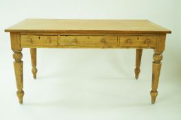 A pine dining table the top with oak cross banding with three frieze drawers on turned legs,