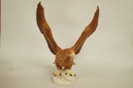 A Beswick figure of a Golden Eagle, with matt glaze, wings outstretched standing on a rocky base,