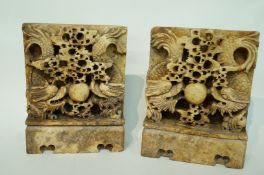 A pair of Chinese carved soap stone bookends each with two dragons chasing a flaming pearl