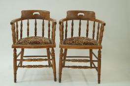 A pair of tub shaped oak armchairs with turned legs and stretchers