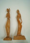 A pair of 20th century Indonesian figures, each on mound bases,
