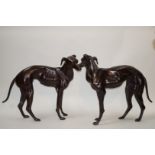 A pair of 20th century bronze models of greyhounds, each standing facing right, 76cm high,