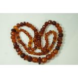 A graduated row of amber beads, the one hundred and eight beads measuring 74cm long,
