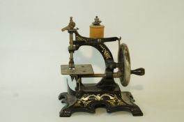 An early 20th century child's Singer sewing machine, with printed gilt decoration on a black ground,