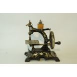 An early 20th century child's Singer sewing machine, with printed gilt decoration on a black ground,