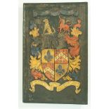 A 20th century carved  armorial wall plaque, painted in colours on a black ground 56cm high,