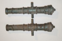 A pair of 20th century cast iron cannon barrels, both painted metallic green,