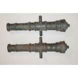 A pair of 20th century cast iron cannon barrels, both painted metallic green,