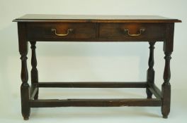 An oak side table, with two frieze drawers on turned legs linked by rectangular stretchers,