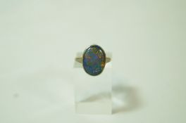A black opal ring, the shallow cabochon to a carved shouldered mount, finger size H, 3.