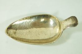 An A. E. Jones silver spoon stand, Birmingham 1929, on three ball feet, 11.5cm long, 71g (2.